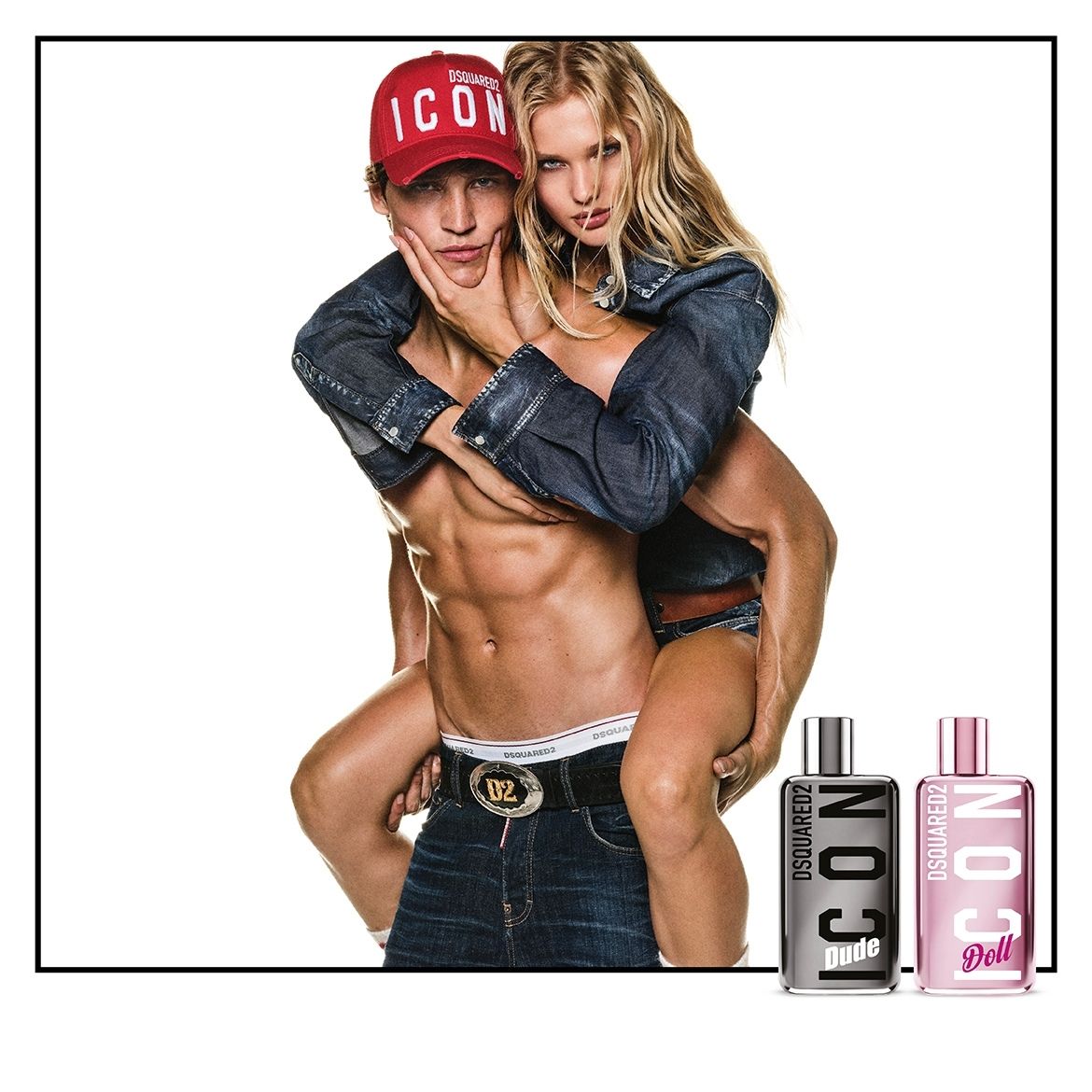 Een man met een rode pet en een vrouw in denimkleding poseren samen, met twee parfumflesjes, Dsquared2 Icon Dude en Icon Doll, op de voorgrond.