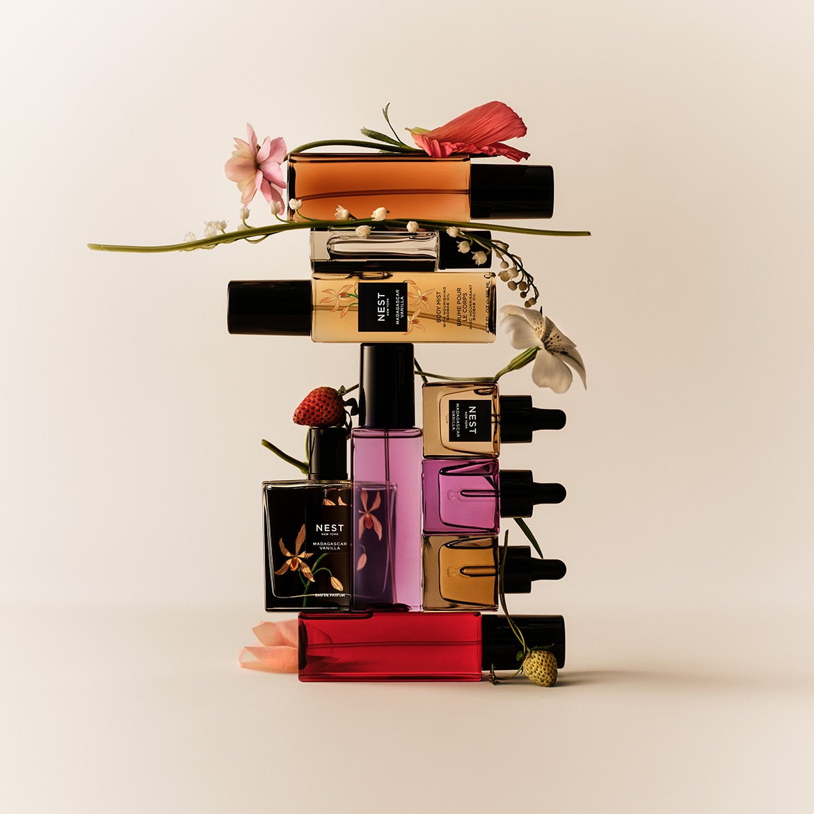 Découvrez la collection Nest Madagascar Vanilla, une pyramide de parfums et brumes corporelles aux notes florales et fruitées, présentés dans des flacons aux couleurs variées, rehaussés de fleurs délicates et d'une fraise.