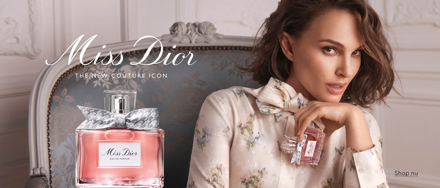 Natalie Portman presenteert Miss Dior, de nieuwe couture-icoon, met een grote fles Miss Dior Eau de Parfum en een kleinere versie in haar hand, en nodigt je uit om nu te winkelen.