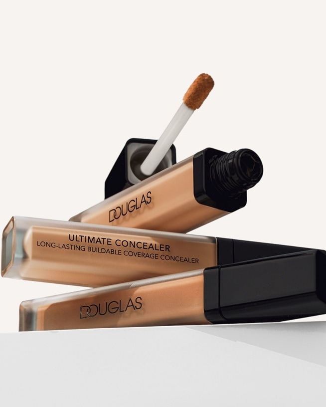 Voici l'anti-cernes Ultimate de Douglas, un correcteur longue durée à couvrance modulable, présenté dans un tube transparent avec un bouchon noir.