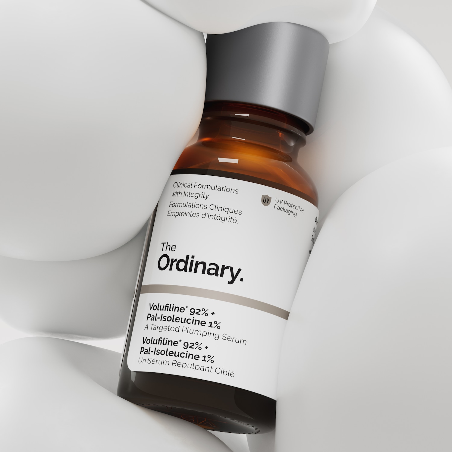 Bruine glazen fles van The Ordinary met een wit etiket, met de tekst 'Volufiline 92% + Pal-Isoleucine 1%', een serum voor een vollere huid, omgeven door witte vormen.