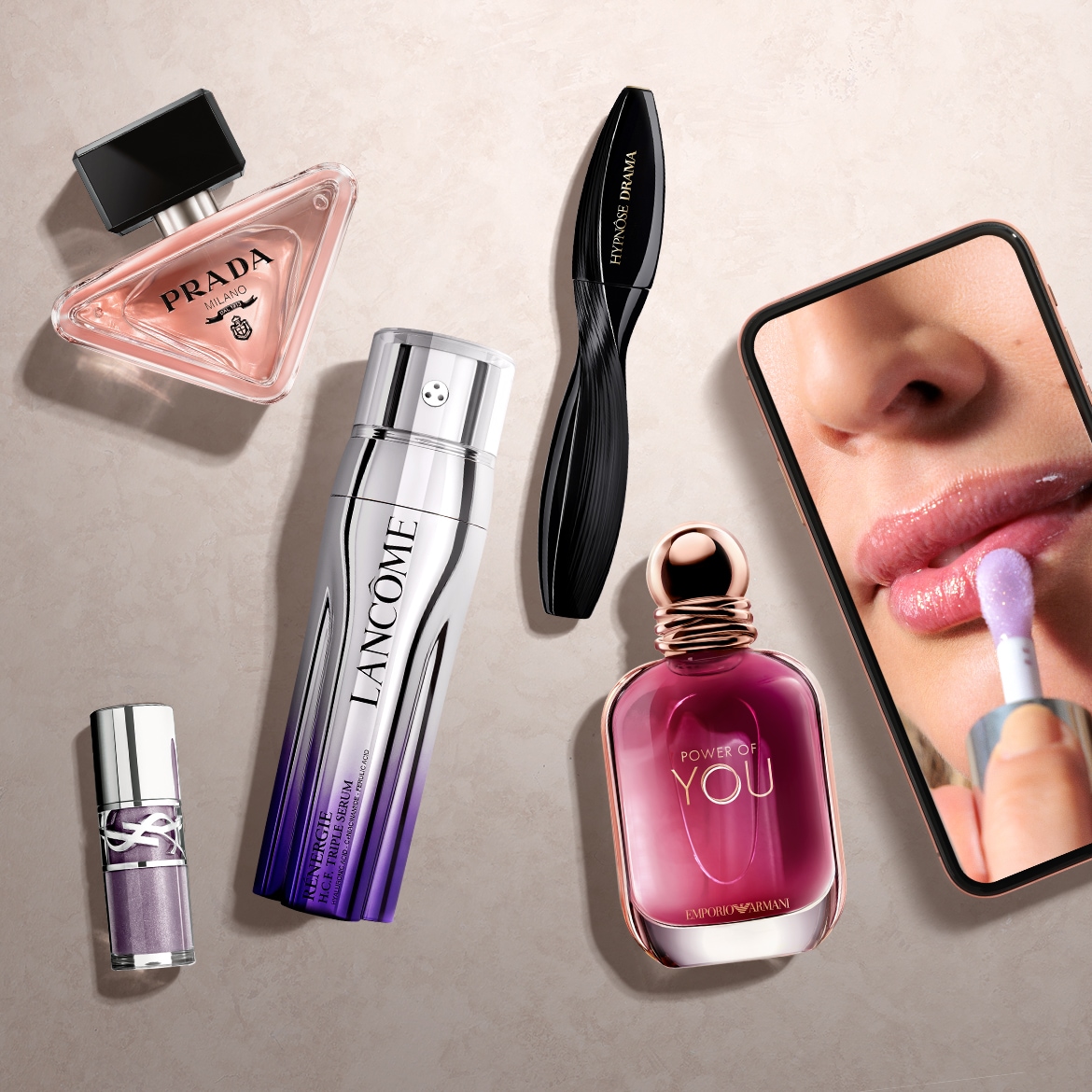 Découvrez un assortiment de produits de beauté, comprenant le parfum Prada Milano dans un flacon triangulaire rose, le sérum Lancôme Rénergie et le mascara Hypnôse Drama, pour rehausser votre routine beauté.