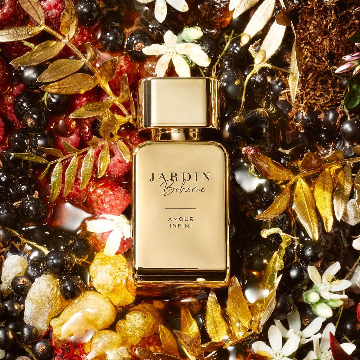 Gouden Jardin Bohème Amour Infini parfumfles omringd door bessen, bloemen en gouden bladeren.