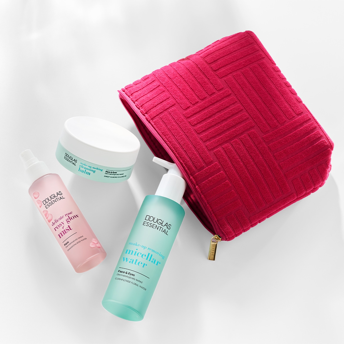 Ontdek de Douglas Essentials set met een roze make-up tas, delicate rozenmist, micellair water en reinigingsbalsem voor een complete huidverzorgingsroutine.